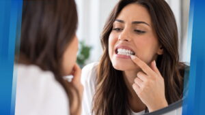 Woman checking her teeth in a mirror for early signs of tooth decay
